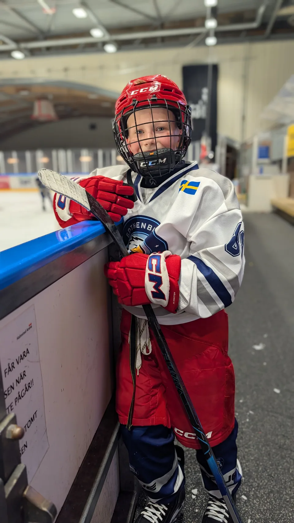En Eagles-spelare med röd hjälm och klubba vid sargen